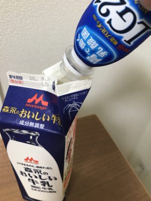 牛乳パックに飲むヨーグルトを注ぐ